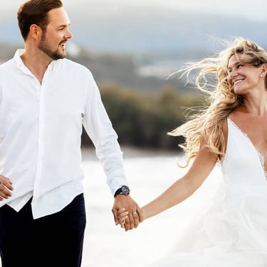 Sguardi complici di una coppia di sposi che corre su una spiaggia