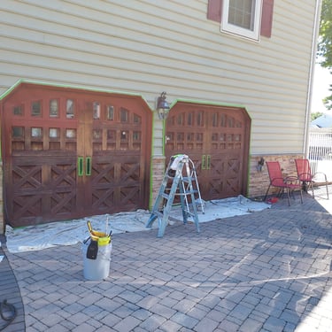 a drive way a car and ladders around garage