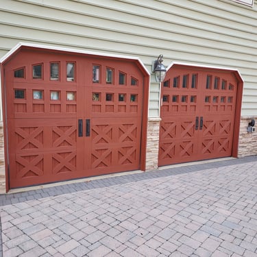  a drive way with 2 painted garage doors