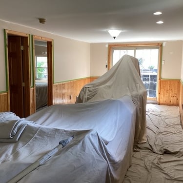 a room with drop clothes covering furinture