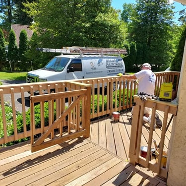 a man with a van painting a deck