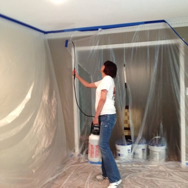 Janet is spraying the ceiling with water before I scrape the popcorn from the ceiling.