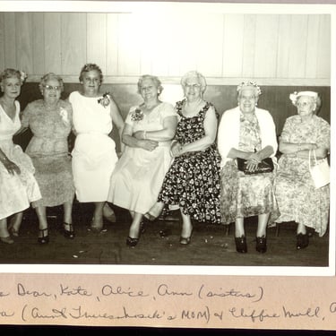 a group of women sitting on a bench in a room