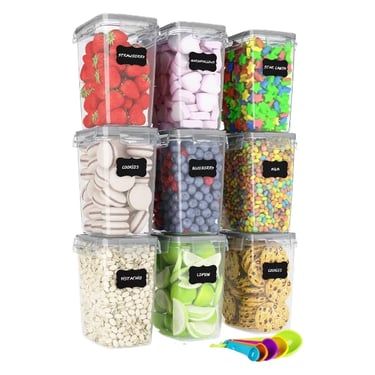 Set of nine clear airtight food storage containers with black chalkboard labels for pantry organization.
