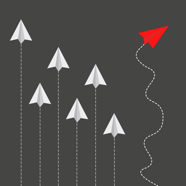 a red paper airplane flying over a group of paper airplanes
