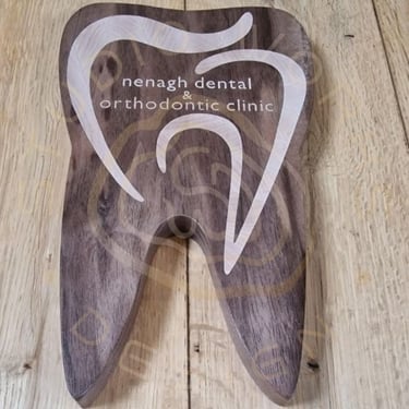 Tooth-shaped sign with logo inlay