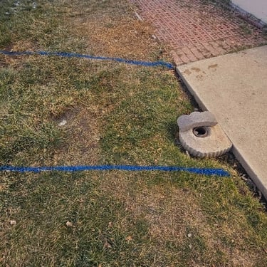 blue paint marking a leak at a mobile home park between 2 homes