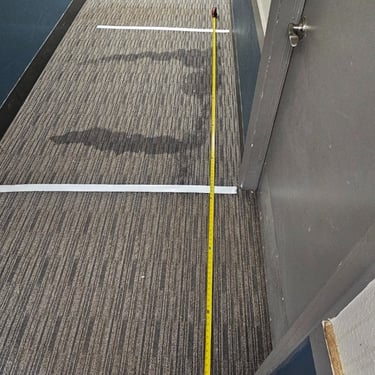 leak in hallway marked with tape and measurements