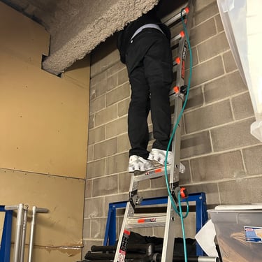man injecting tracer gas into a cavity for a building investigation