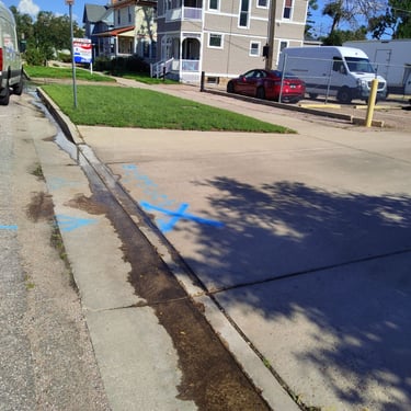 leak marked in blue paint downtown Colorado Springs at a commercial property