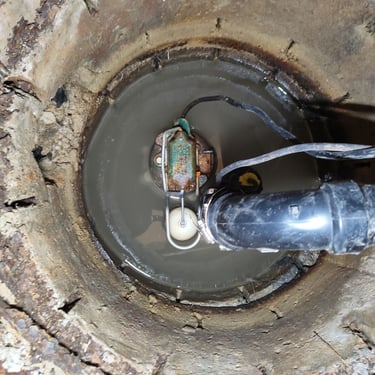 old sump pump in a sump pit that is falling apart