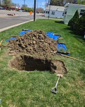 hole in the grass digging a leak 