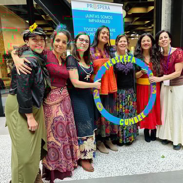 a group of women in colorful dresses holding a large blue circle