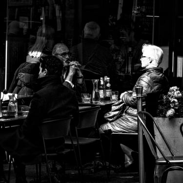 A woman, her face bathed in light is highlighted against shadows. Cockburn Street, Edinburgh