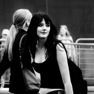 A young woman glances over her shoulder as she crosses the street at Waverley Bridge, Edinburgh