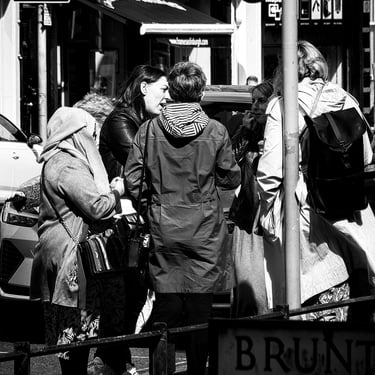A small group of women stand in the sun having a chat in Bruntsfield, Edinburgh