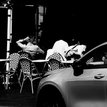 People sit in shadow at a street cafe on Cockburn Street, Edinburgh