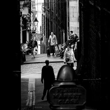 A woman, silhouetted and framed by the walls of the close. with Cockburn Street in light. Fleshmarket Close, Edinburgh