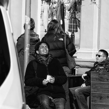 A woman, enjoying the sun on her face, at Waverley Bridge, Edinburgh