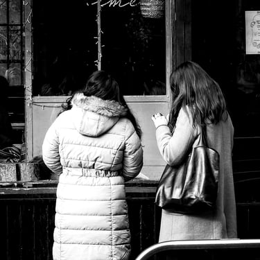 Two women look through the window of a cafe on West Port, Edinburgh