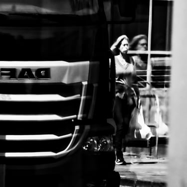 A woman and a large truck reflected in glass at Fountainbridge, Edinburgh