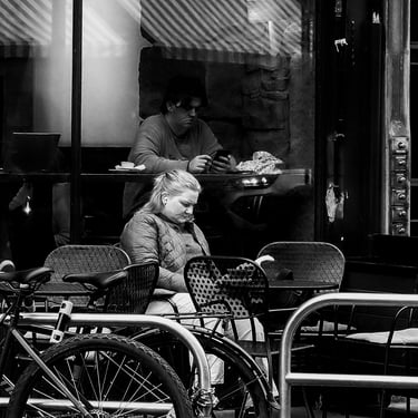 A woman sits outside a cafe, reading a book in Bruntsfield, Edinburgh