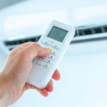 Adjusting the temperature of an air conditioner in a room or home using a remote controller for precise climate control.