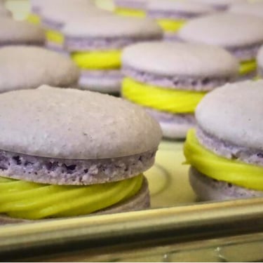 Artisanal French macarons, featuring delicate shells and creamy passion fruit ganache filling, for special occasions.