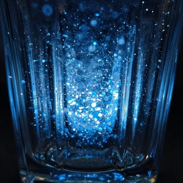 Abstract close-up of light refracting through cast glass, deep blue hues.