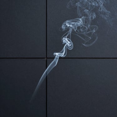 A subtle wisp of smoke against a matte dark architectural surface.