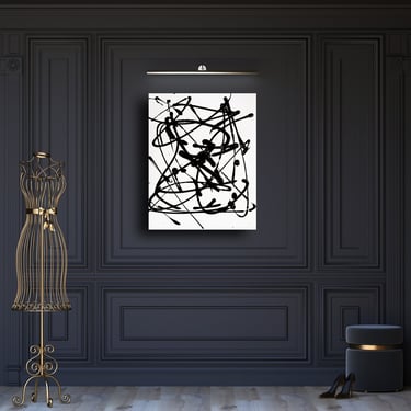 Black and white abstract drip painting by Olivia Seger on a dark wall with a gold dress form.