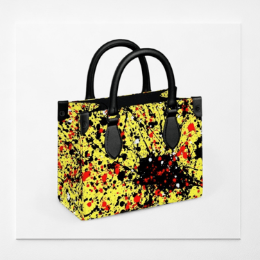 Handbag by Vymoyre with abstract yellow, red, and black paint splatter pattern and black handles.
