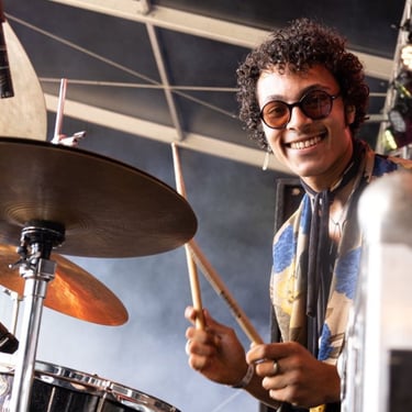 a man with glasses and a scarf on a stage