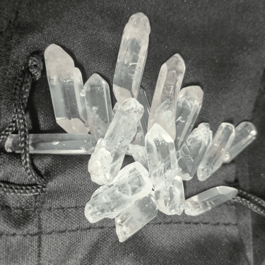 a collection of white crystals on a velvet drawstring bag