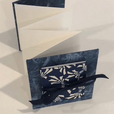 Accordion with Japanese paper and small accordion on cover, ribbon detail