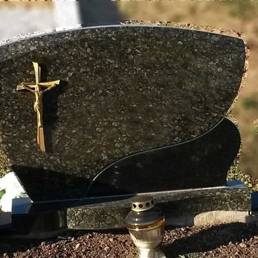 žalios spalvos vienos dalies paminklas su kryžiumi