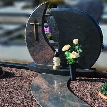 juodos spalvos kareliško akmens paminklas su rudo akmens deriniu