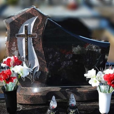 juodos spalvos kareliško akmens paminklas su rudo akmens deriniu