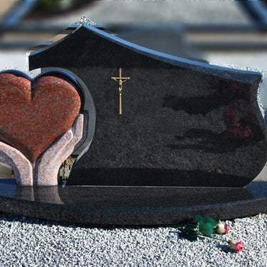 juodos spalvos kareliško akmens paminklas su rudo akmens širdimi