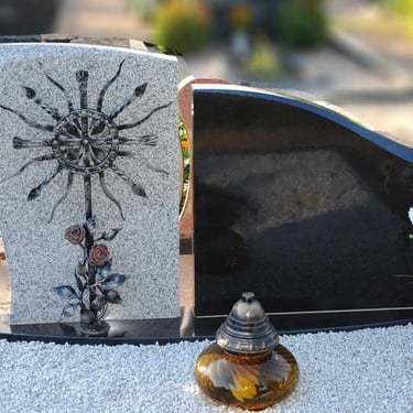 juodos spalvos paminklas su pilko akmens deriniu