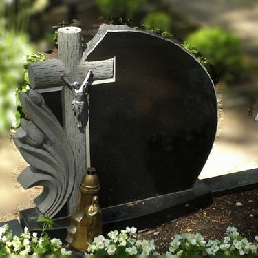 Juodos spalvos kareliško akmens vienos dalies paminklas su graviruotu kryžiumi