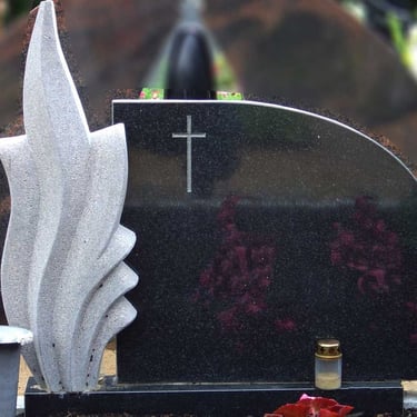 juodos spalvos paminklas su pilko akmens deriniu