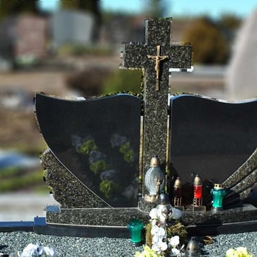 juodos spalvos švediško akmens paminklas su žalios spalvos kryžiumi