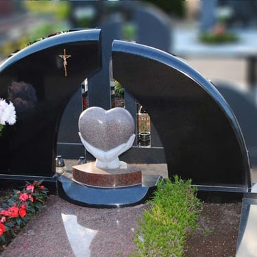 juodos spalvos paminklas su rudo akmens širdimi