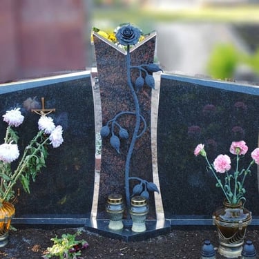 juodos ir rudos spalvos trijų dalių paminklas su metaline rože