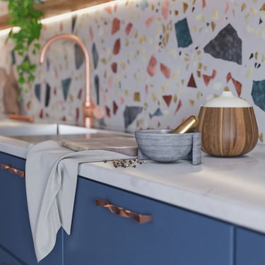 3D rendering of modern kitchen with blue cabinets, copper handles, terrazzo backsplash, and wooden accessories.