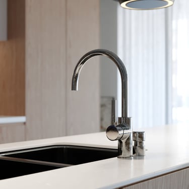 3D rendering of modern kitchen: steel faucet, black sink, white countertop, pendant light, and wood panels.