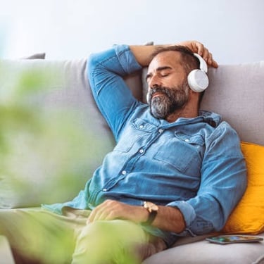 Homme écoutant chez lui une relaxation sonore enregistrée spécialement pour lui.