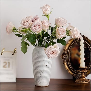 a vase with pink roses in a vase on a table