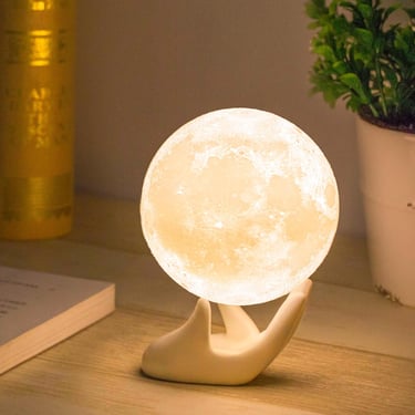 a white moon shaped lamp with a handmade moon